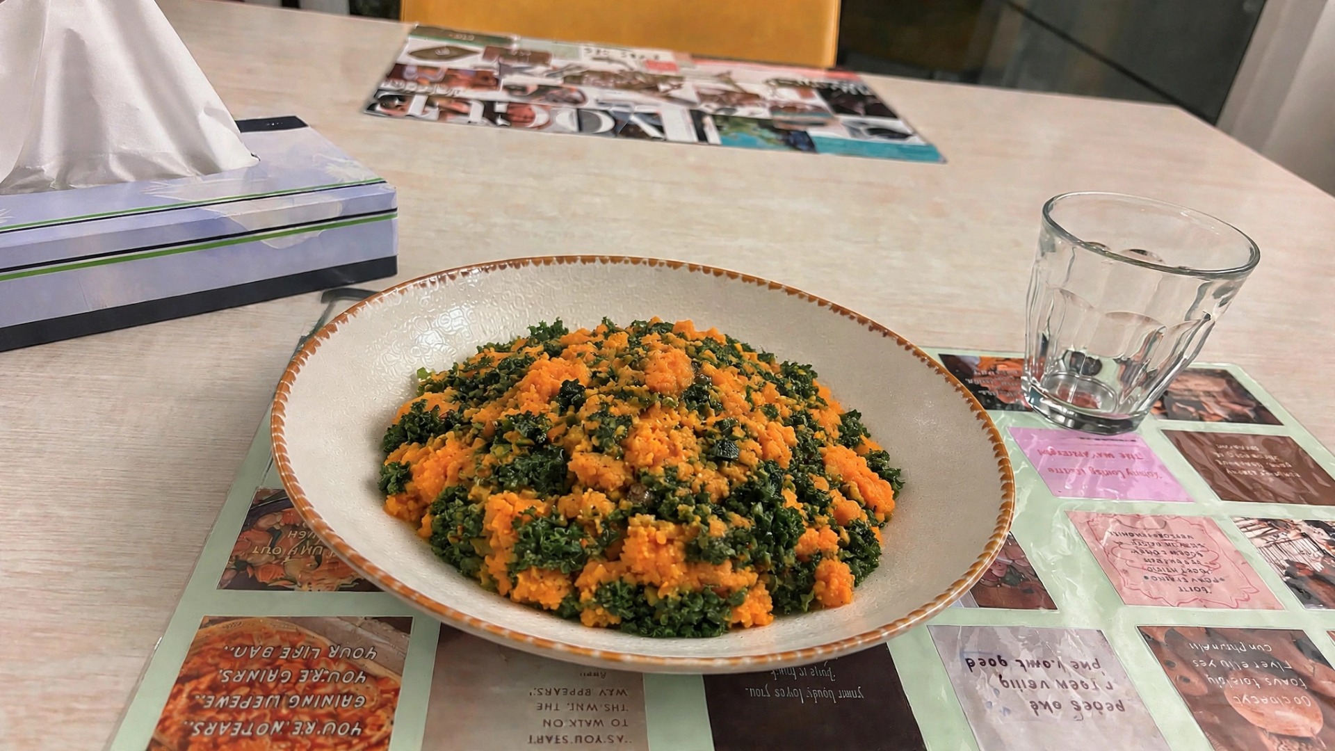 Grote schaal met boerenkool van zoete aardappel oranje en groene stukjes op tafel, met glazen en verpakkingen eromheen. Eetstoorniskliniek. Avondeten. Opname. Eetstoornis. Anorexia. Herstellen.